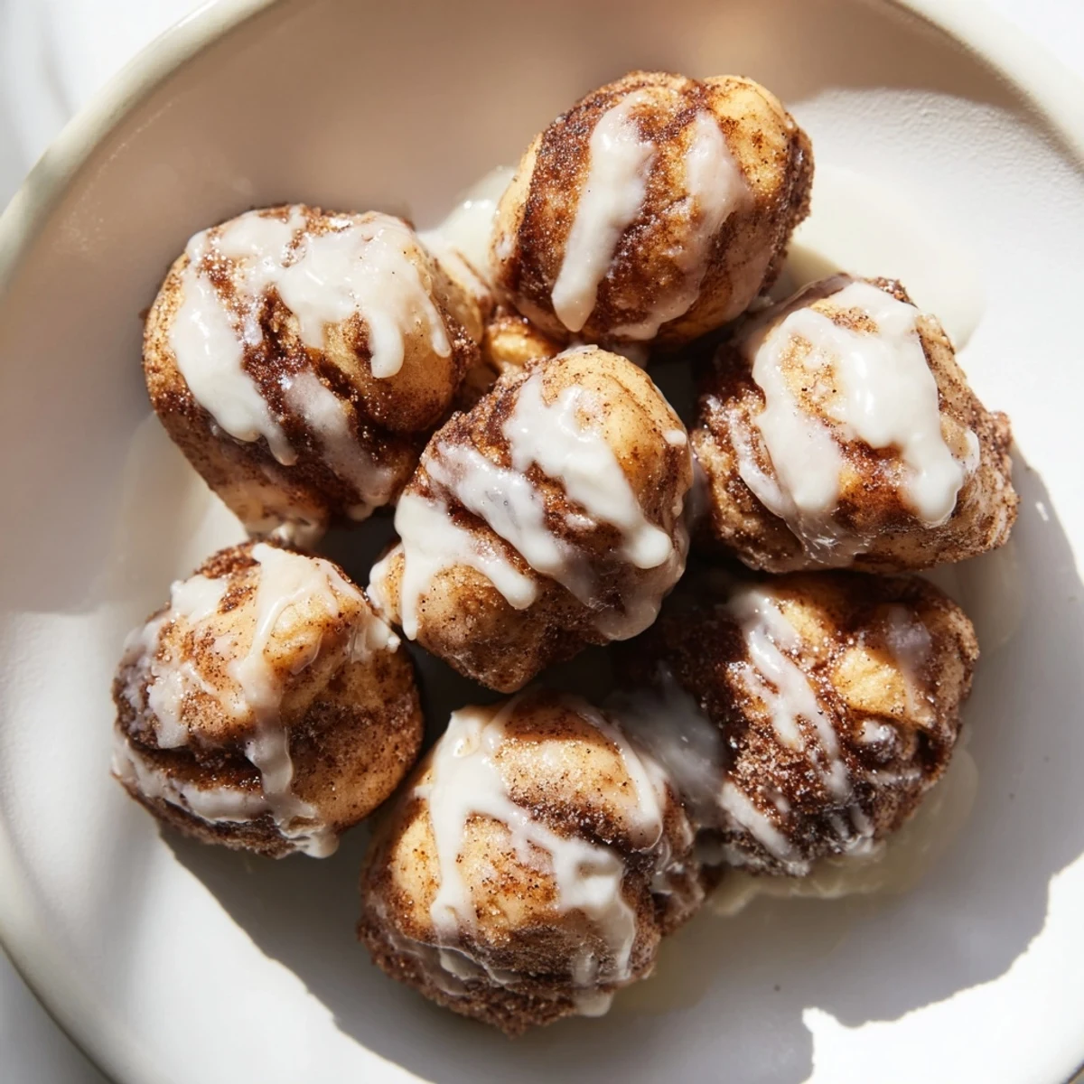 Soft Warm Cinnamon Roll Bites coated in sweet cinnamon sugar and glaze.  