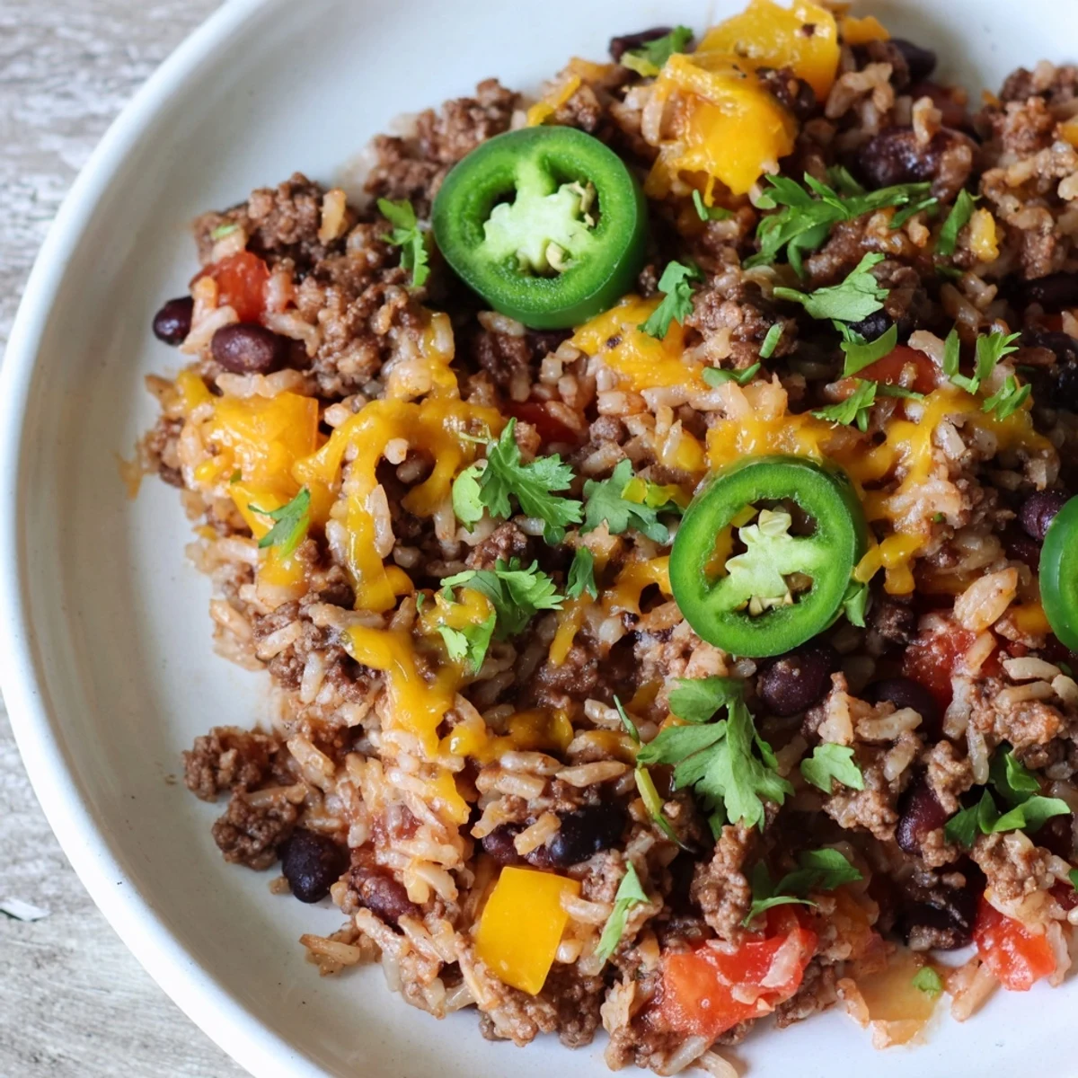 A bubbling Tex-Mex Beef & Rice Casserole, topped with melted cheddar, ready to scoop and serve.