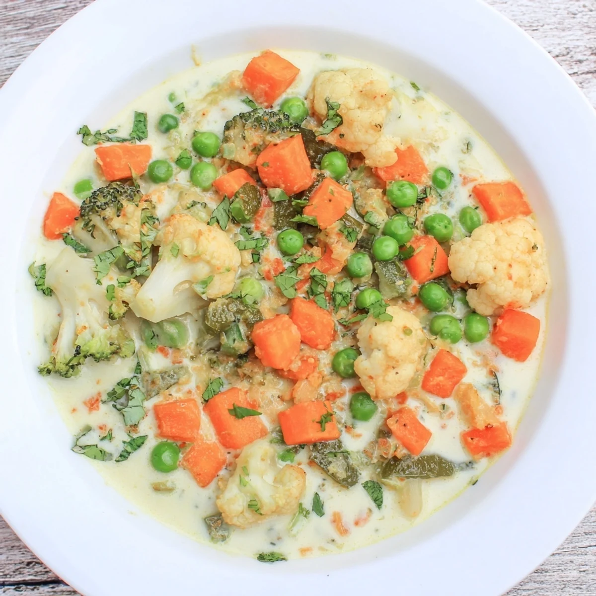 Golden Veggie Coconut Curry, garnished with cilantro, served in a bowl with fluffy rice.