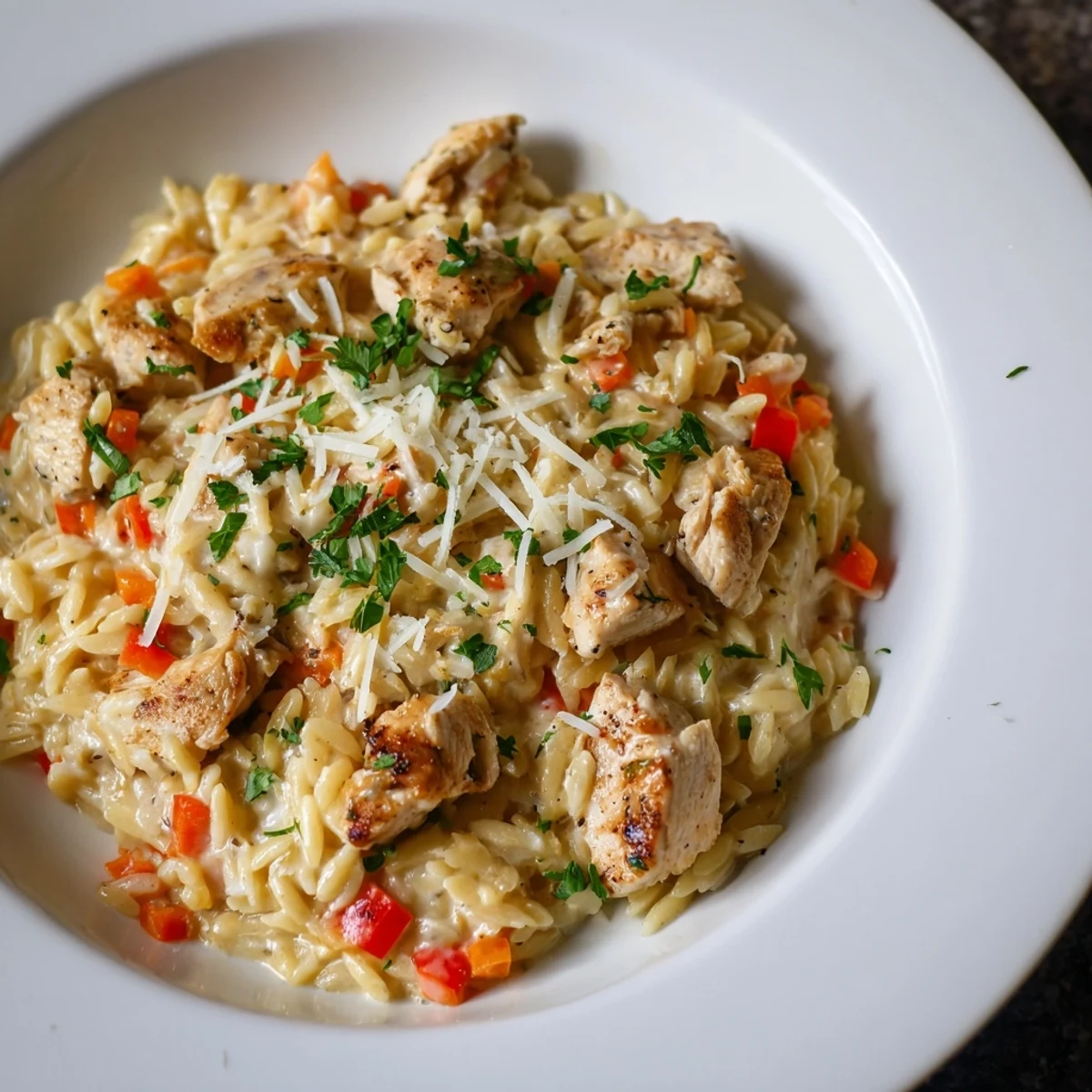 This image presents the finished One-Pot Cajun Chicken Alfredo Orzo, a satisfying dinner with a spicy aroma.