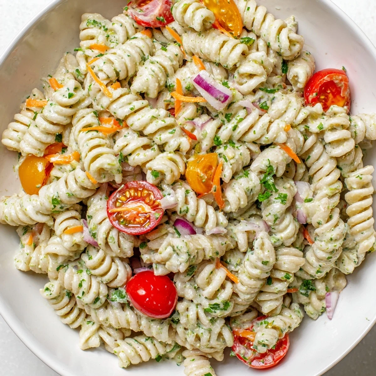 A big bowl of chilled Vegan Hemp Seed Ranch Pasta Salad, showcasing colorful vegetables and delicious flavors.