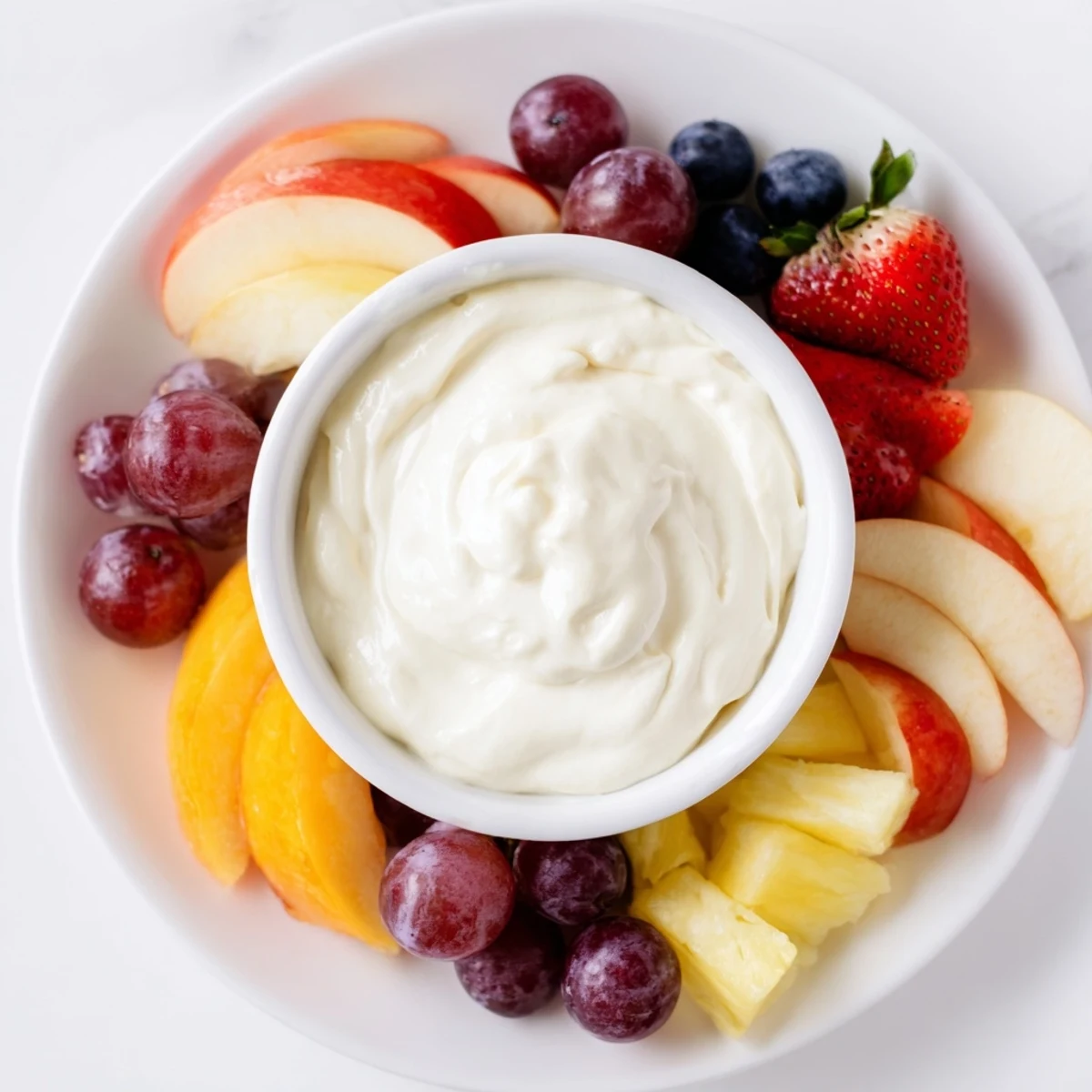 A close-up of a delightful cream cheese fruit dip, ready to be scooped and enjoyed with berries.