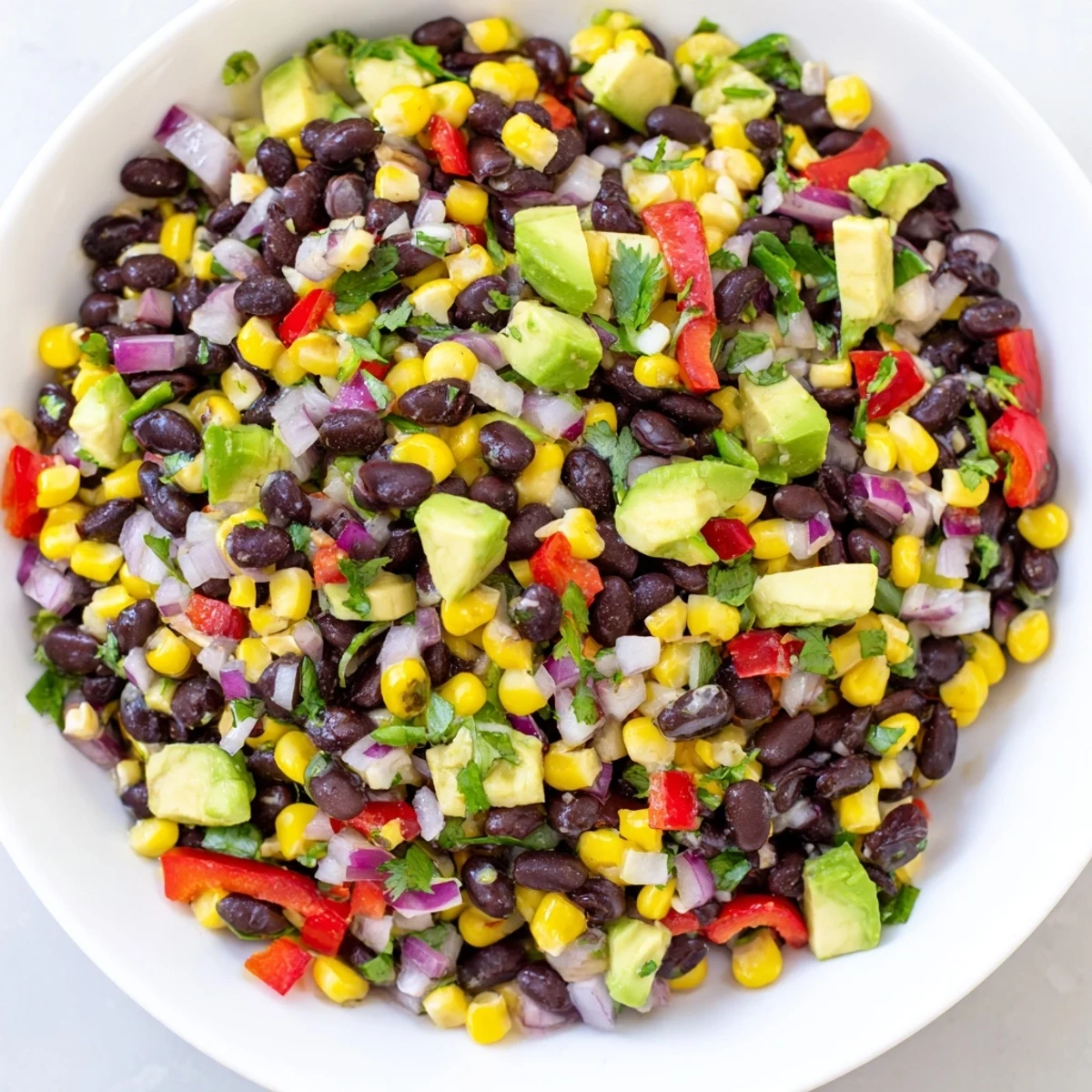 Vibrant Southwestern black bean and corn salad, featuring juicy corn and spicy jalapeños, ready to eat.