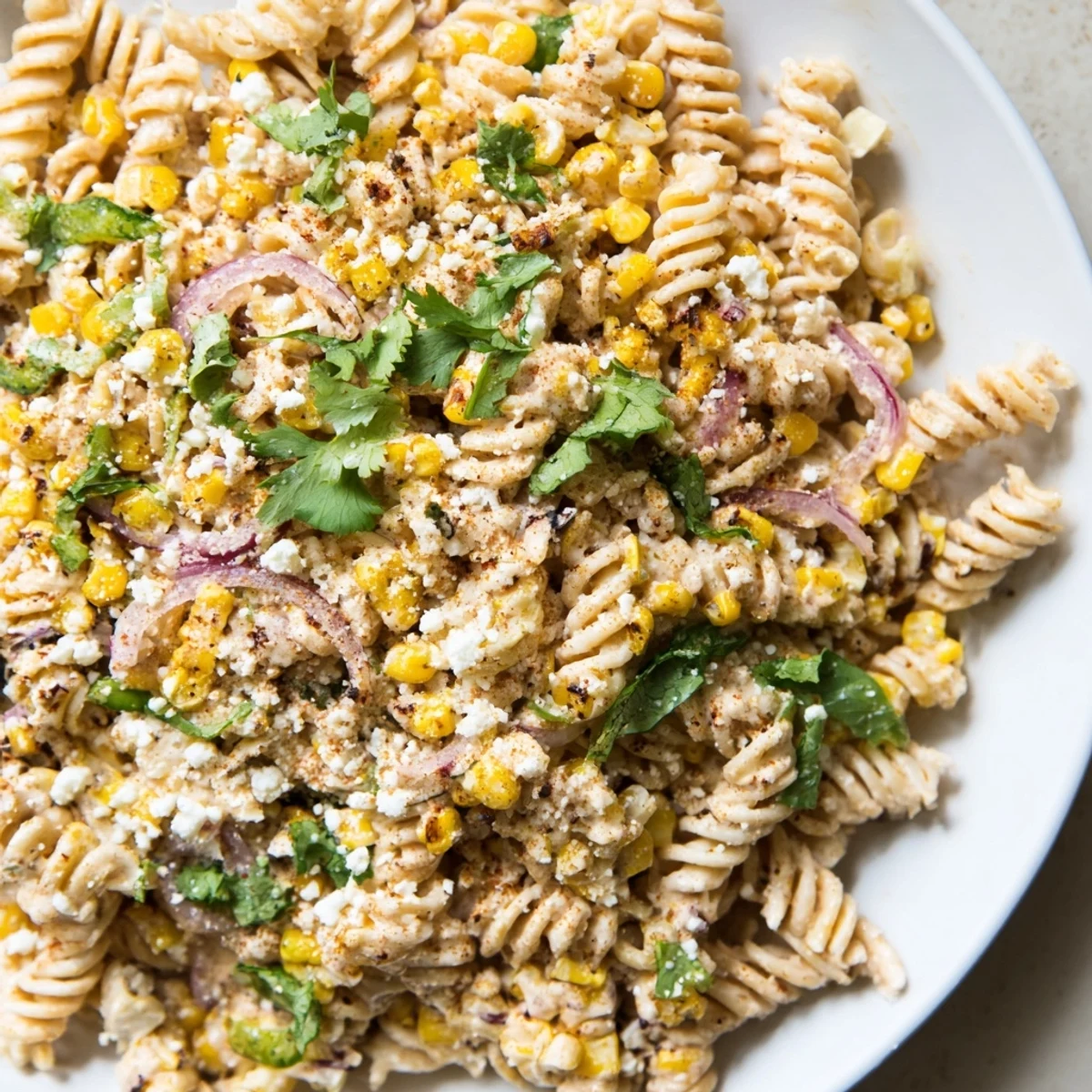 Creamy Street Corn Pasta Salad showcases a vibrant mix of corn, pasta, and fresh herbs in a bowl.