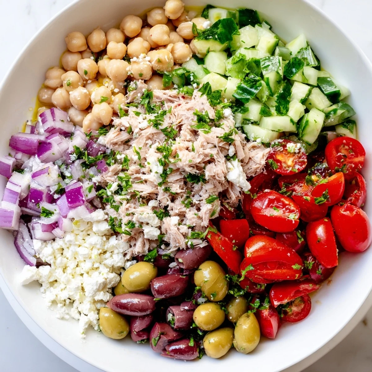Close-up of a Tuna Chickpea Salad, showcasing vibrant ingredients drizzled with flavorful dressing.