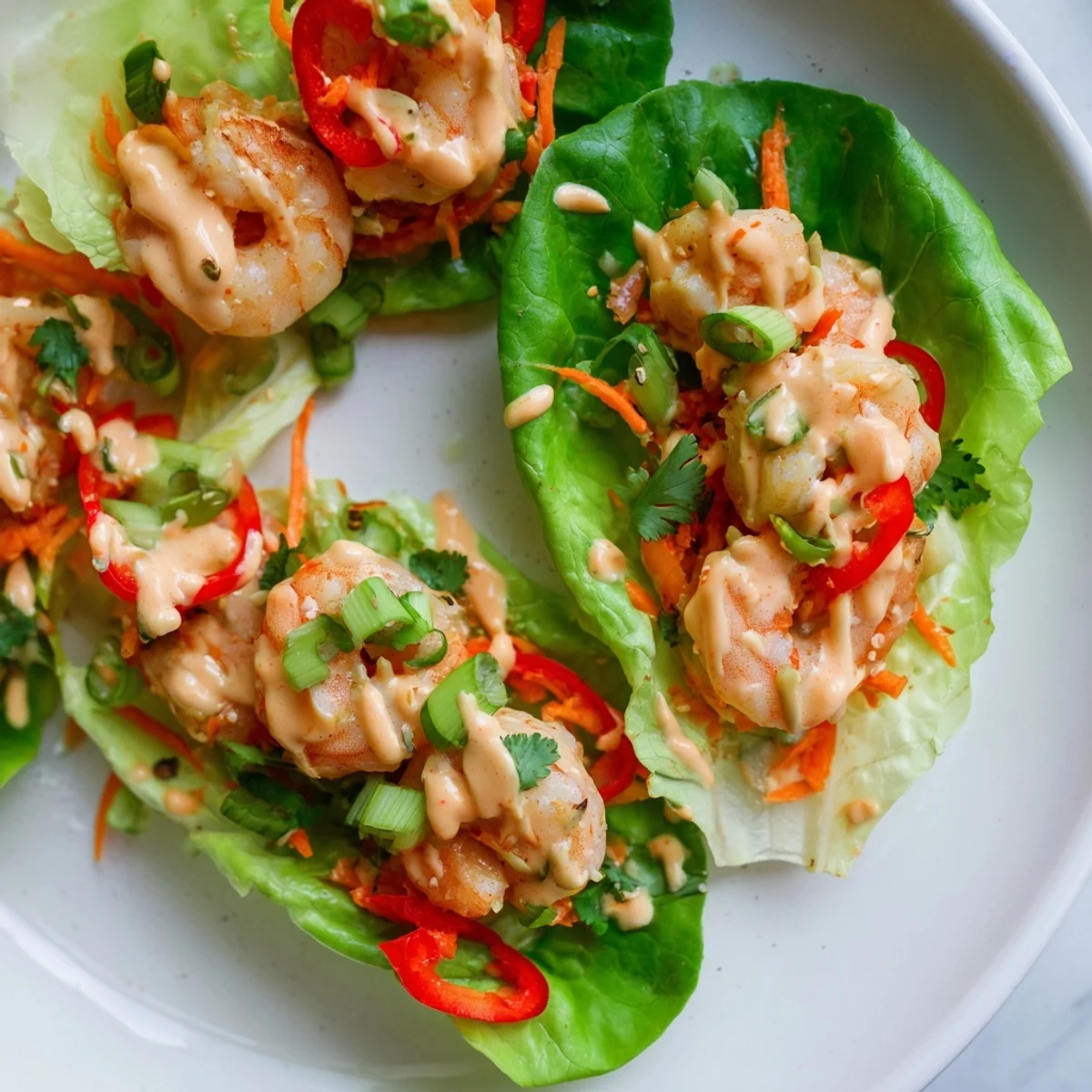Beautiful, close-up view of ready-to-eat shrimp lettuce cups, showcasing perfectly cooked shrimp and colorful veggies.