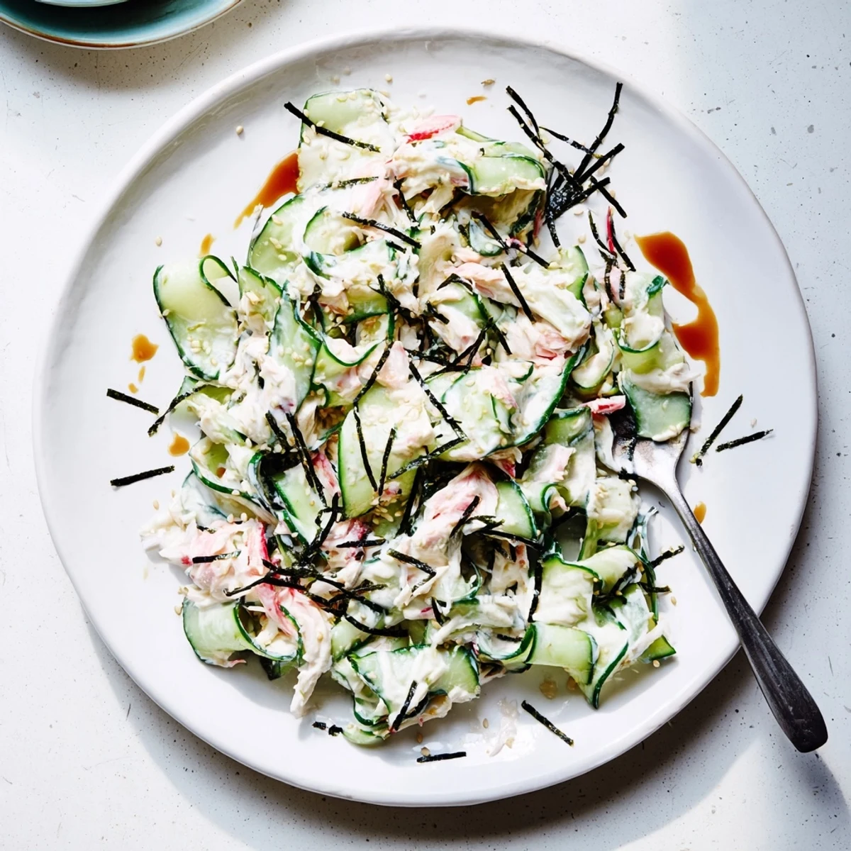 Tossed California Roll Cucumber Salad with creamy mayo dressing, sesame oil, and savory toppings.