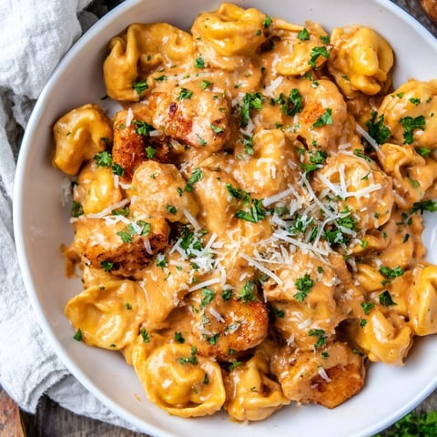 Zesty Cajun Garlic Parmesan Chicken Tortellini: creamy pasta dish with tender chicken, ready to serve with parsley.