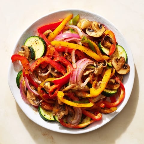 Vibrant veggie skillet fajitas sizzling in a cast-iron pan, perfect for a quick and flavorful Tex-Mex dinner.