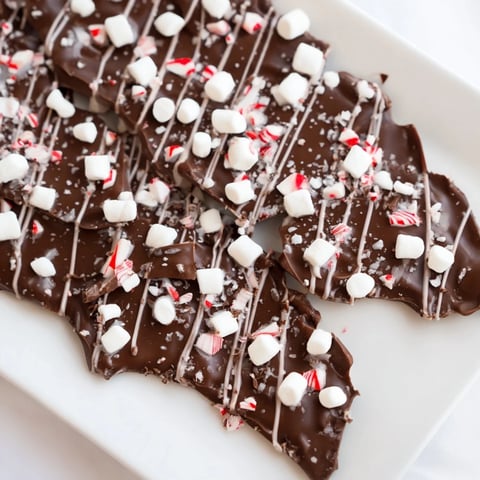 Delicious Hot Chocolate Bomb Bark with white chocolate drizzle, marshmallows, and festive sprinkles.