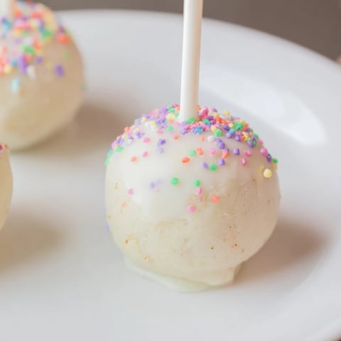 White chocolate-covered Lightened-Up Sugar Cookie Cake Pops, a delicious, bite-sized American dessert treat.