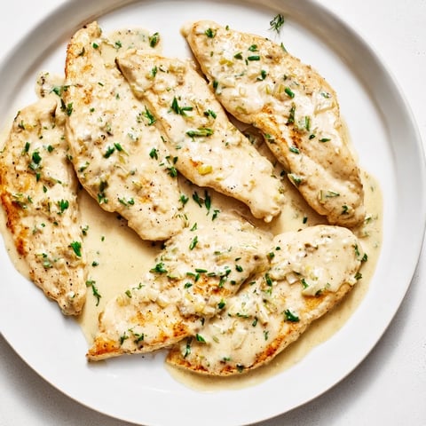Golden-brown Lighter Creamy Tarragon Chicken, glistening in a light sauce, ready for your plate.