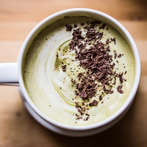 Steaming Collagen Peppermint Mocha Matcha Latte, a vibrant green and cocoa-colored, frothy, delicious beverage.
