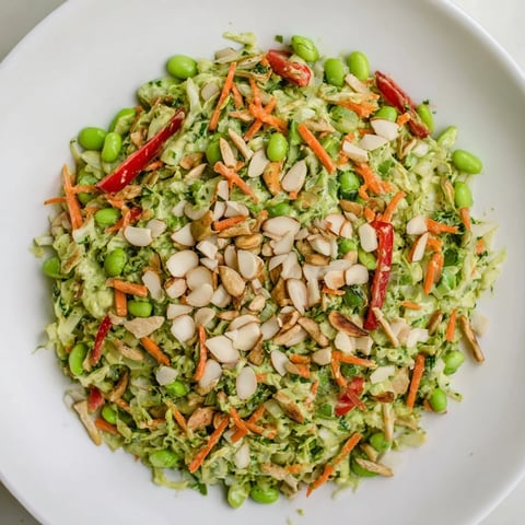 A colorful bowl of Crunchy Cabbage and Edamame Salad, ready to eat with a vibrant Green Goddess dressing.