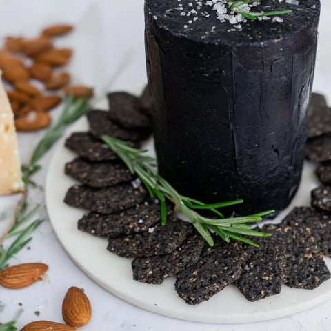 A striking cheese platter, the Obsidian Peak, features black wax cheddar with dark crackers.