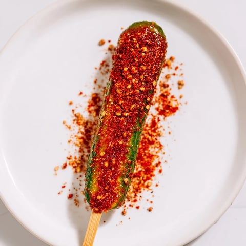 Golden Chamoy-Tajín pickle sticks: tangy, spicy, and perfectly coated for a delicious snack.