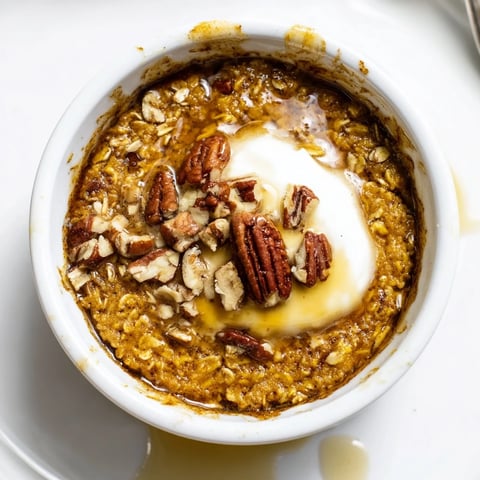 Golden, baked Pumpkin Spice Baked Oats, topped with pecans, ready for a cozy breakfast experience.