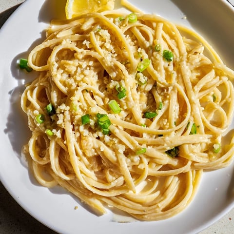 Steaming bowl of miso butter pasta, glistening noodles coated in a rich, savory sauce with Parmesan.