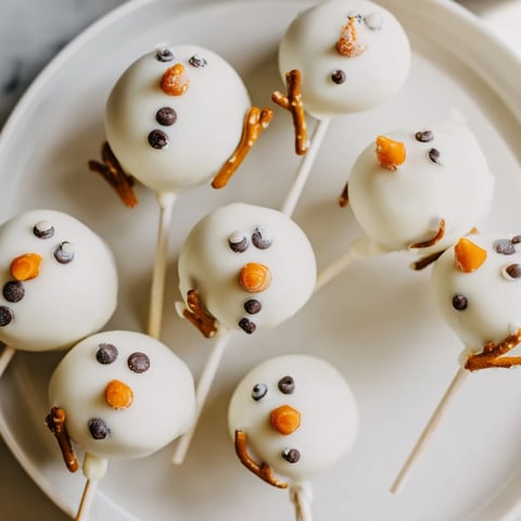 Fluffy Oreo Snowman Cake Pops, coated in white chocolate, ready for a winter party.