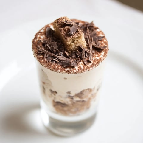 Deconstructed tiramisu shots, a sweet Italian dessert layered in clear shot glasses, ready to serve.