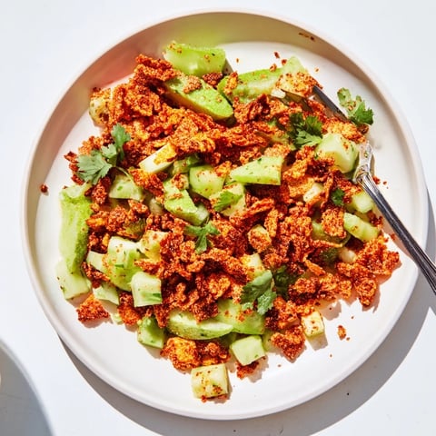Bright red Flamin Hot Cheeto Salad with diced cucumber and fresh cilantro, tossed in a zesty lime-hot sauce dressing for a crunchy, spicy snack.