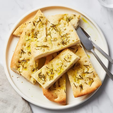 Aromatic rosemary garlic focaccia bread, highlighting its soft texture and rich flavors.  