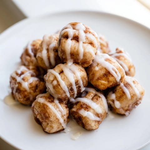 Pillowy dough Warm Cinnamon Roll Bites, drizzled with glaze, perfect for breakfast.  