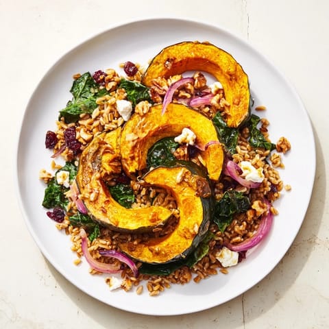 Golden acorn squash atop a Farro & Mustard Green Salad, ready to be tossed with tangy vinaigrette.