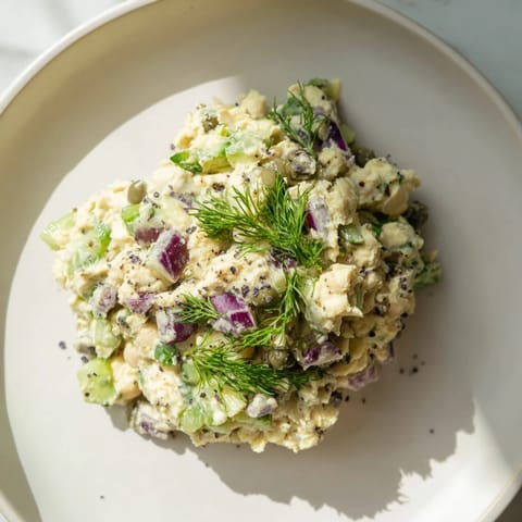 Chunky chickpea tuna salad boasting celery and pickle, perfect for a light and refreshing meal.