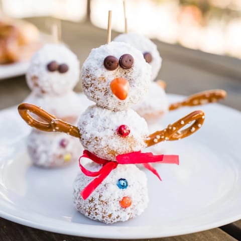 Enjoy these adorable Mini Donut Snowman stacks, perfect for holiday parties, with pretzel arms.