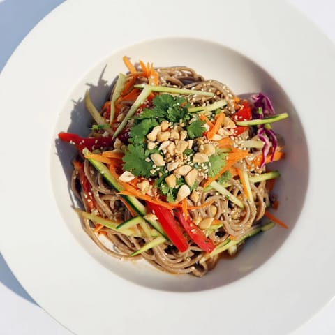 This Cold Noodle Salad features soba noodles and crisp veggies coated in sesame-ginger dressing, ready to enjoy.