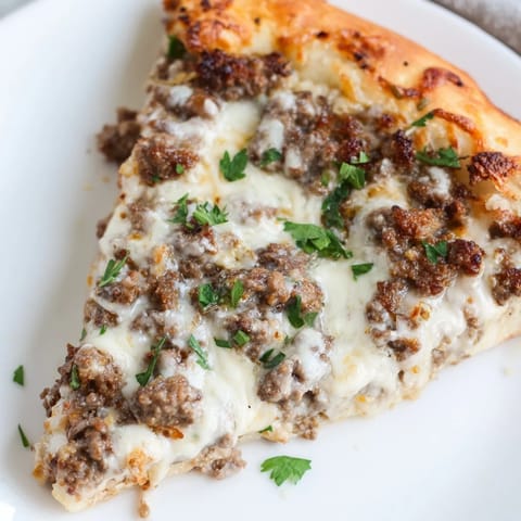Golden, baked Ground Beef Alfredo Pizza, ready to eat, showing off a perfectly cooked, crispy crust.