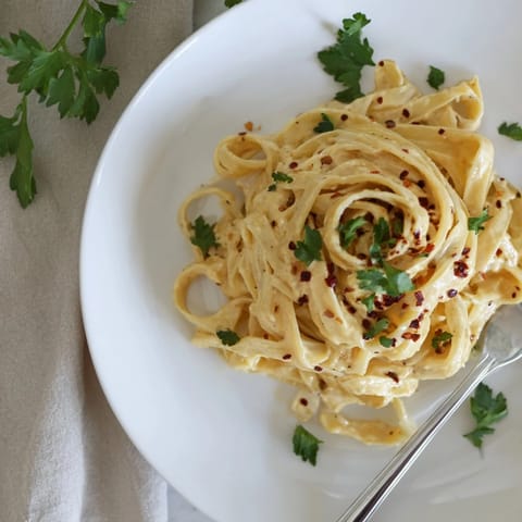 Sriracha Honey Pasta tossed in a glossy, sweet-spicy garlic butter sauce, served warm with extra red pepper flakes.  