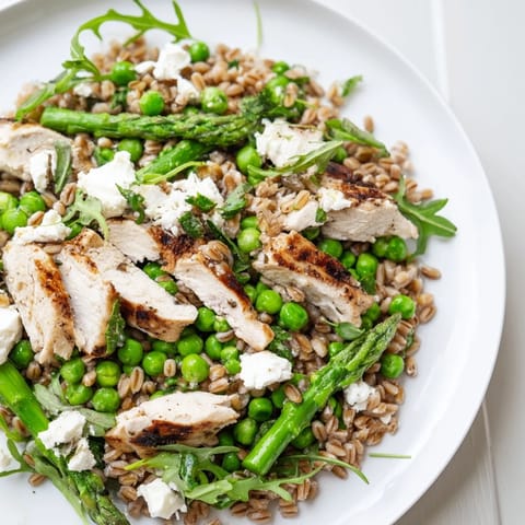 Tender farro and juicy chicken mingle with bright green peas and peppery arugula in this salad.