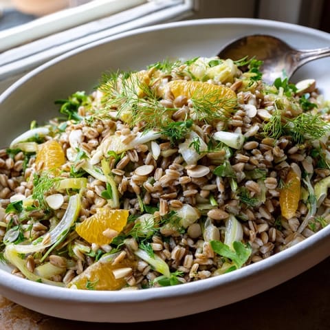 Hearty Mediterranean Farro Salad With Fennel, Oranges, and Almonds served on a rustic plate, ready for a refreshing lunch.