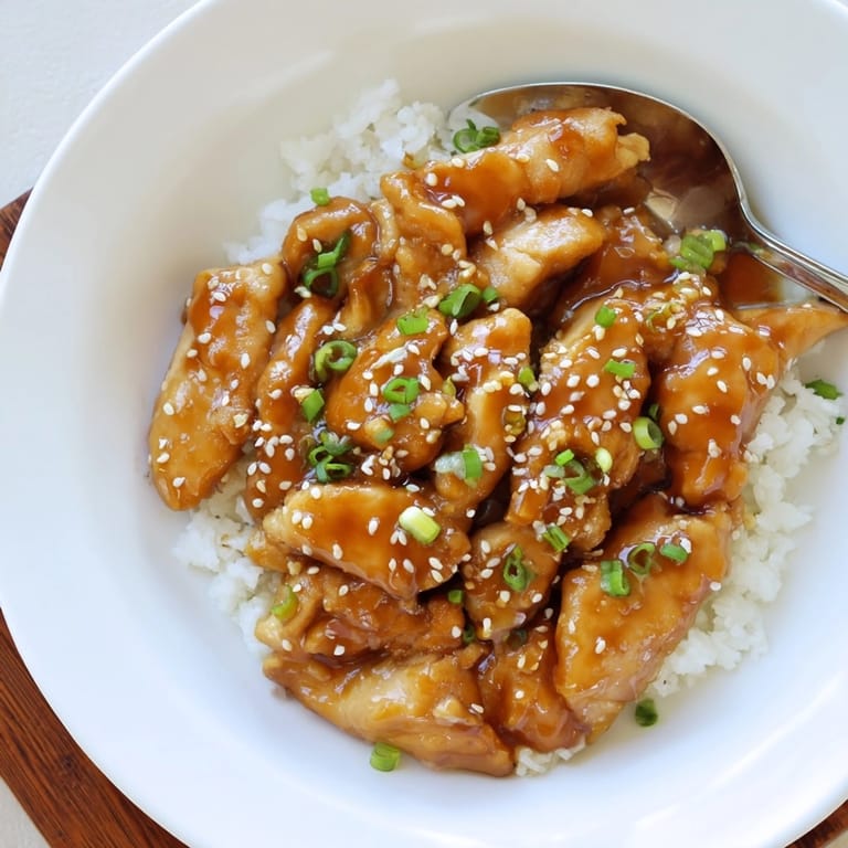 Delicious, saucy Slow Cooker Honey Garlic Chicken thighs ready for dinner and garnish.