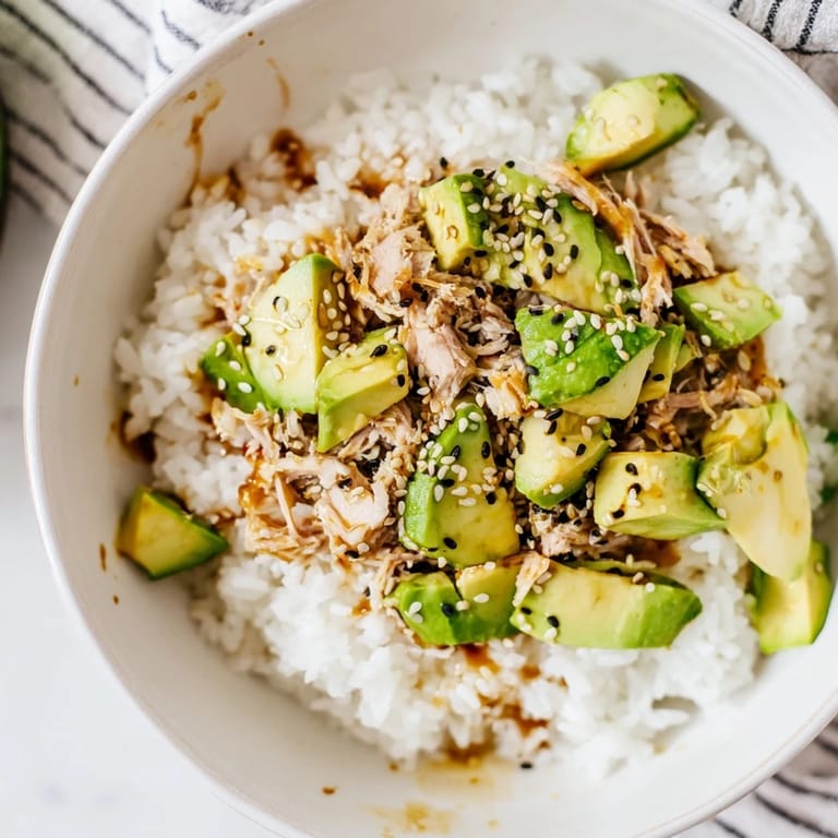 Serving the nourishing Tuna Avocado Rice Bowl in a bowl, garnished with nori strips and cilantro for an Asian-inspired meal.