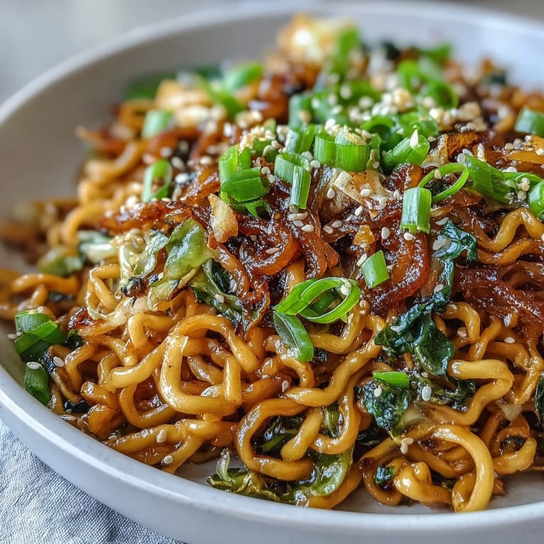 Quick savory weeknight Fried Cabbage Ramen in a wok, loaded with julienned carrots, garlic, ginger, and a glossy sesame soy sauce.